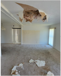An empty room with a large hole in the ceiling